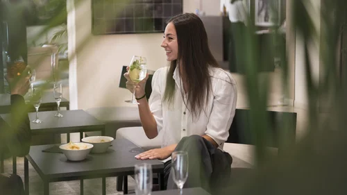 Boutique Hotel a Verona · Touring 3★ · A 2 min da Piazza Erbe Donna che sorseggia una bevanda in un bar con tavoli e snack