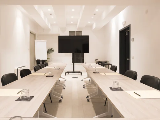 Boutique Hotel a Verona · Touring 3★ · A 2 min da Piazza Erbe Sala riunioni moderna con tavoli, sedie nere e schermo TV grande